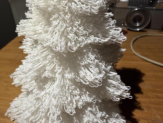 Close up of the texture of the tree; spindly loops of white filament give the impression of an organic shape. 