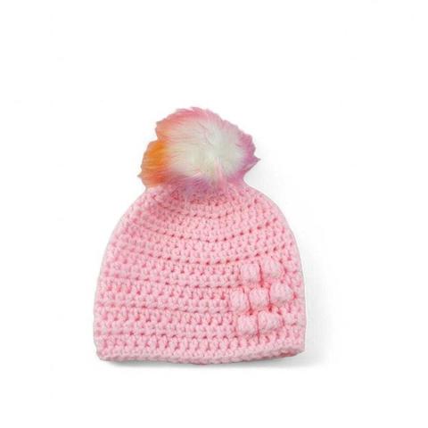 The photo features a pink crocheted hat with a colourful fluffy pom-pom on top and bobble details, set against a plain white background.