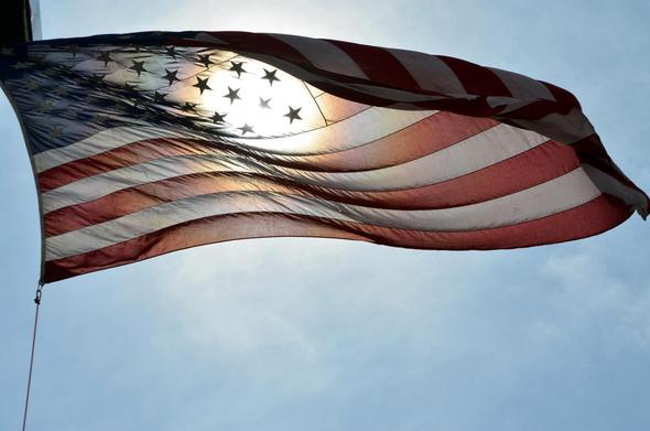 United States flag with sun faintly shining through