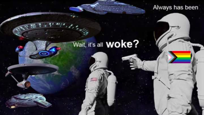 Two astronauts meme. White spacesuits one stands behind the other holding a gun, wearing a rainbow progress pride patch. We see various Star Trek ships and a distant green and blue planet. One says "Wait, it's all woke?" The one holding the gun says "Always has been"