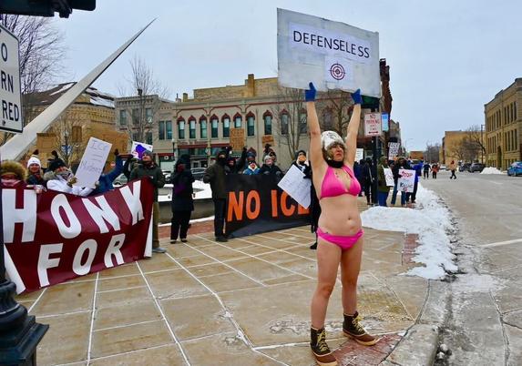 A person in a bikini protesting fascism in the cold.