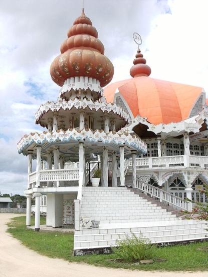 a close-up of one of the spired pavilions, lots of writing and inscriptions on it and decorations, the sky behind is cloudy with blue peeking through 