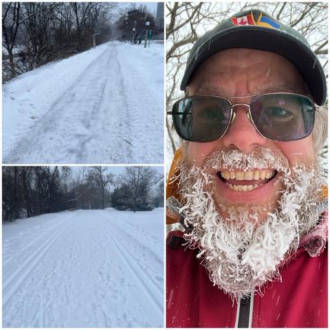 Grid of three photos:
1) Slightly out-of-focus photo of a ploughed path with trees on the left site and some falling snow.
2) A snowy path through parkland with ski tracks on either side with trees in the distance under a grey sky.
3) Selfie of a white bearded man with glasses, a black ball cap with Canadian and Ukrainian flags on it, an orange hoodie, a red outer coat, and a beard covered in snow. #IceBeard