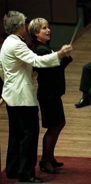 Photograph of a woman and a man conducting an orchestra together