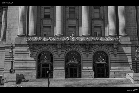 A cinematic black and white photo of San Francisco City Hall in California with a US flag in front.