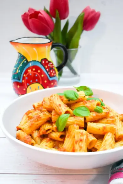 Bowl of rigatoni pasta coated in a very tasty, quick red pepper & avocado sauce.