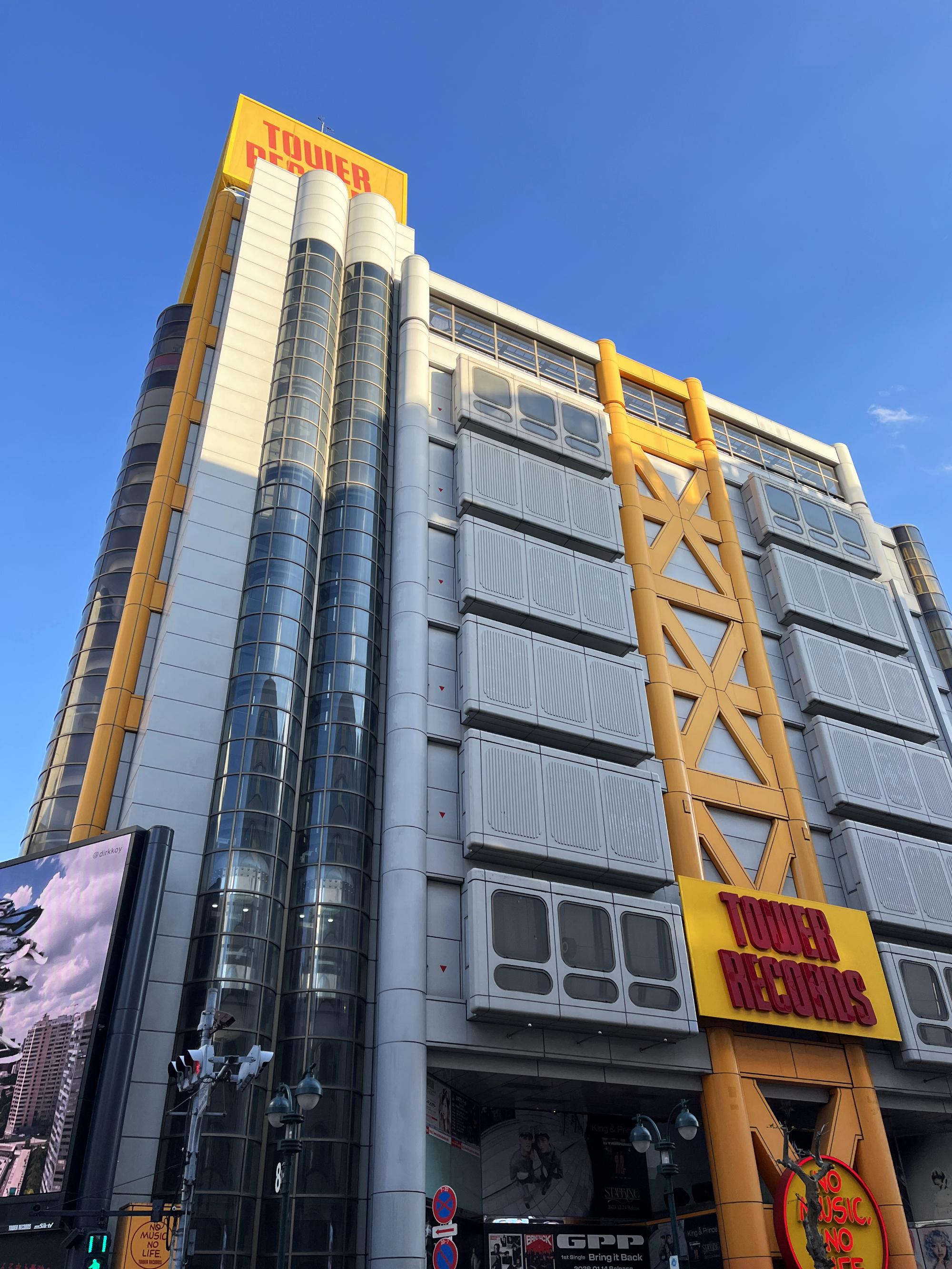 Looking up at the amazing grey and yellow Tower Records building from street level Shibuya.