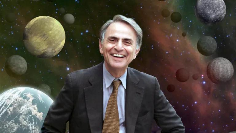 A photo of a smiling Carl Sagan about 10 years older than he was when Cosmos first aired, in front of a backdrop of space, full of planets, gaseous nebulae, and stars.