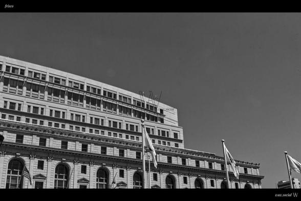 A government building in San Francisco with flags in the foreground.
