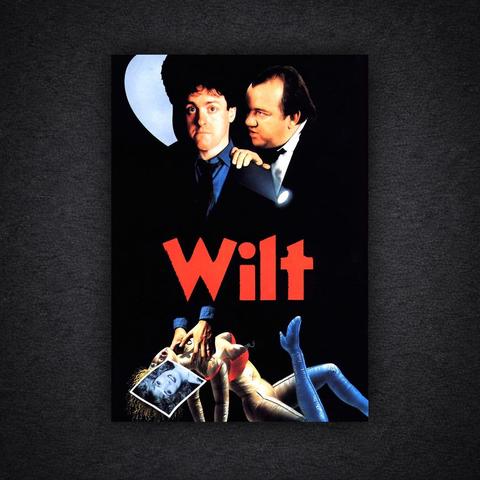 Film poster for Wilt. Two men in dark suits are shown against a black background. One man stands behind the other, resting a hand on his shoulder and holding a torch that points downward. At the bottom of the image is a life-sized mannequin lying on the floor with a black-and-white photograph placed over its face. The film title “Wilt” appears in large red letters in the centre of the poster.