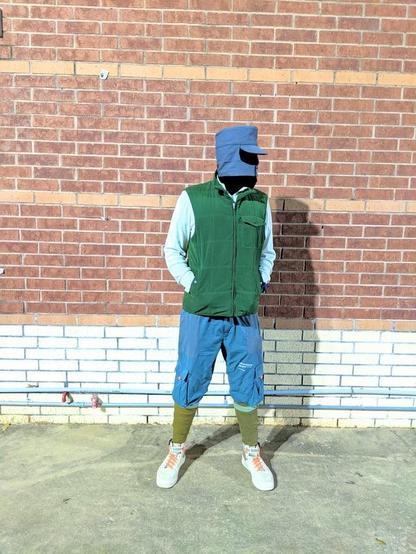 Me in a Finnish grey military cap, while jacket with green parka, green cargo pants, green puttees, white kicks.