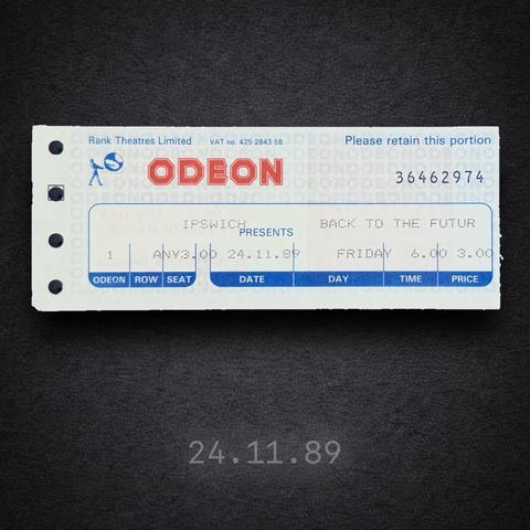 Printed ODEON cinema ticket on a dark background. The ticket shows the ODEON logo and “Rank Theatres Limited” at the top. The cinema location is Ipswich. The film title reads “Back to the Future II”. The date is Friday 24 November 1989, with a start time of 6.00 pm. The ticket includes row and seat fields and a printed serial number on the right. The perforated edge with punched holes is visible on the left.