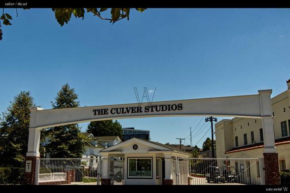 A warm color photo of The Culver Studios in Culver City, California framed by trees and buildings.