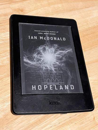 Kindle, auf dem die Titelseite von Ian McDonalds Buch Hopeland zu sehen ist. Erkennbar ist eine elektrische Entladung und eine Turmspitze.