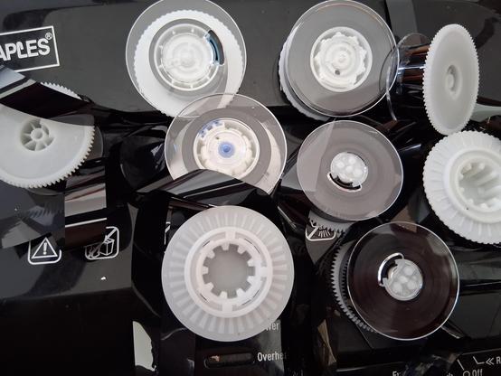 a pile of inner spools from the inside of vhs-c media in varying shades of white, black and semi-translucent gray