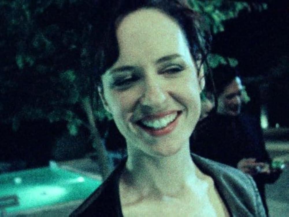 Flashback of a woman smiling near a pool at night.
