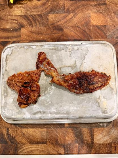 A small baking tray overturned with crispy lamb fat on it. It was sandwiched between two trays and set under the broiler while heating up to bake the manouche. 
