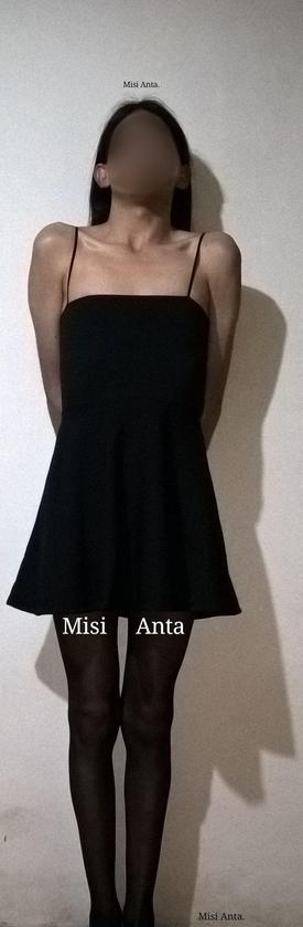 Misi Anta. Chica trans en vestido negro y medias nylon.