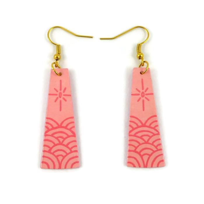 Boucles d'oreilles fantaisie pendantes en forme de longs trapèzes rose pastel ornés de vagues et d'un soleil stylisés rose bonbon.
Les perles sont réalisées en CD recyclé, découpées et peintes à la main, puis recouvertes de résine époxy.
Les crochets sont en métal argenté, mais sont disponibles dans d'autres coloris et métaux.