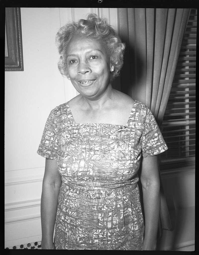 Dorothy B. Porter is standing in front of window.