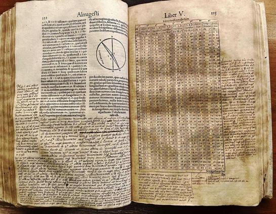 spread pages of a 16th century printing of The Almagest
A historian has discovered that a 16th century printing of The Almagest—a highly influential ancient astronomy text—contains extensive annotations from Galileo Galilei, the astronomer who later overthrew that text’s conception of a geocentric cosmos.