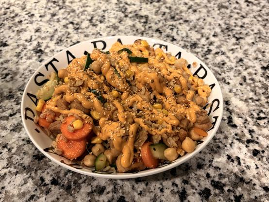 A bowl on a quartzite countertop (I’m pretty sure it’s quartzite…rock people feel free to chime in) with my kinda poke fixins

We’ve got chicken, carrots, cucumber, corn, garbanzo beans, brown rice, and farro

All topped with sriracha mayo and some toasted sesame seeds