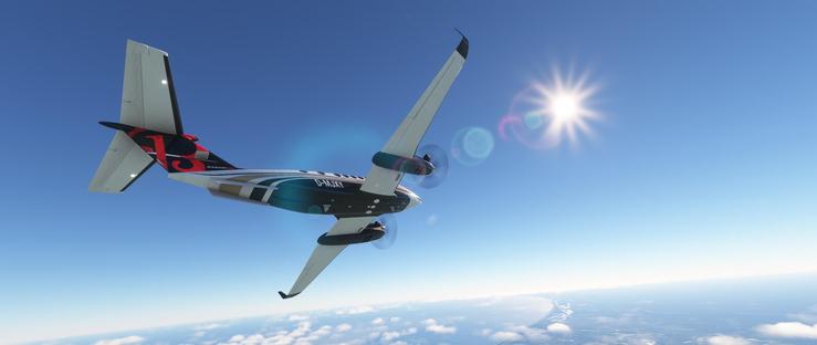 A twin-engine turboprop aircraft is airborne under a bright sun, its light gray fuselage accented with dark blue and white panels near the tail. The registration D-MJXY is prominently displayed on the forward section, while the tail features a bold red design with black elements. Both propeller engines mounted under the wings are in motion, suggesting active flight. The plane is angled slightly upward, appearing to climb or bank. The backdrop consists of a clear, deep blue sky with the sun shining intensely near the upper right, casting lens flares and a gentle glow. Below, a layer of fluffy white clouds sits just above the horizon, with a distant landmass partially visible through the cloud cover. The overall scene depicts a smooth flight at high altitude on a clear day.