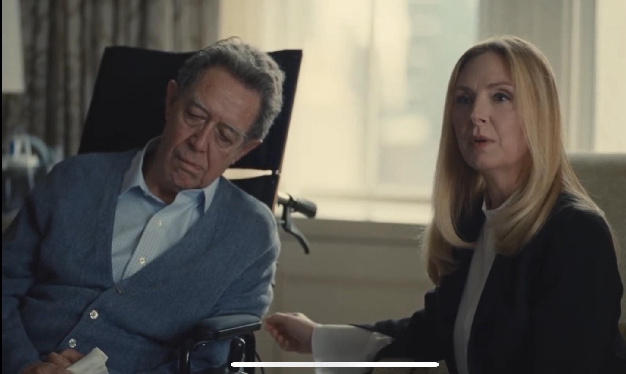 Photo of Sandy in a wheel chair slumped over, and Sandy, his daughter, next to him. Up right and in good health. The juxtaposition of the two.