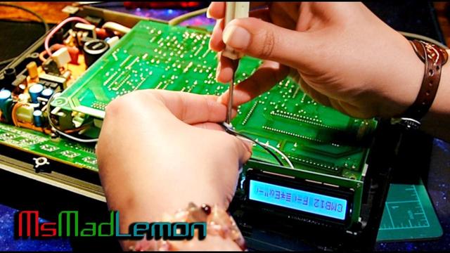 Vintage yamaha tx7 synthesizer on top of a desk, opened, showing all the circuit boards and power module. Being repaired by Maddi