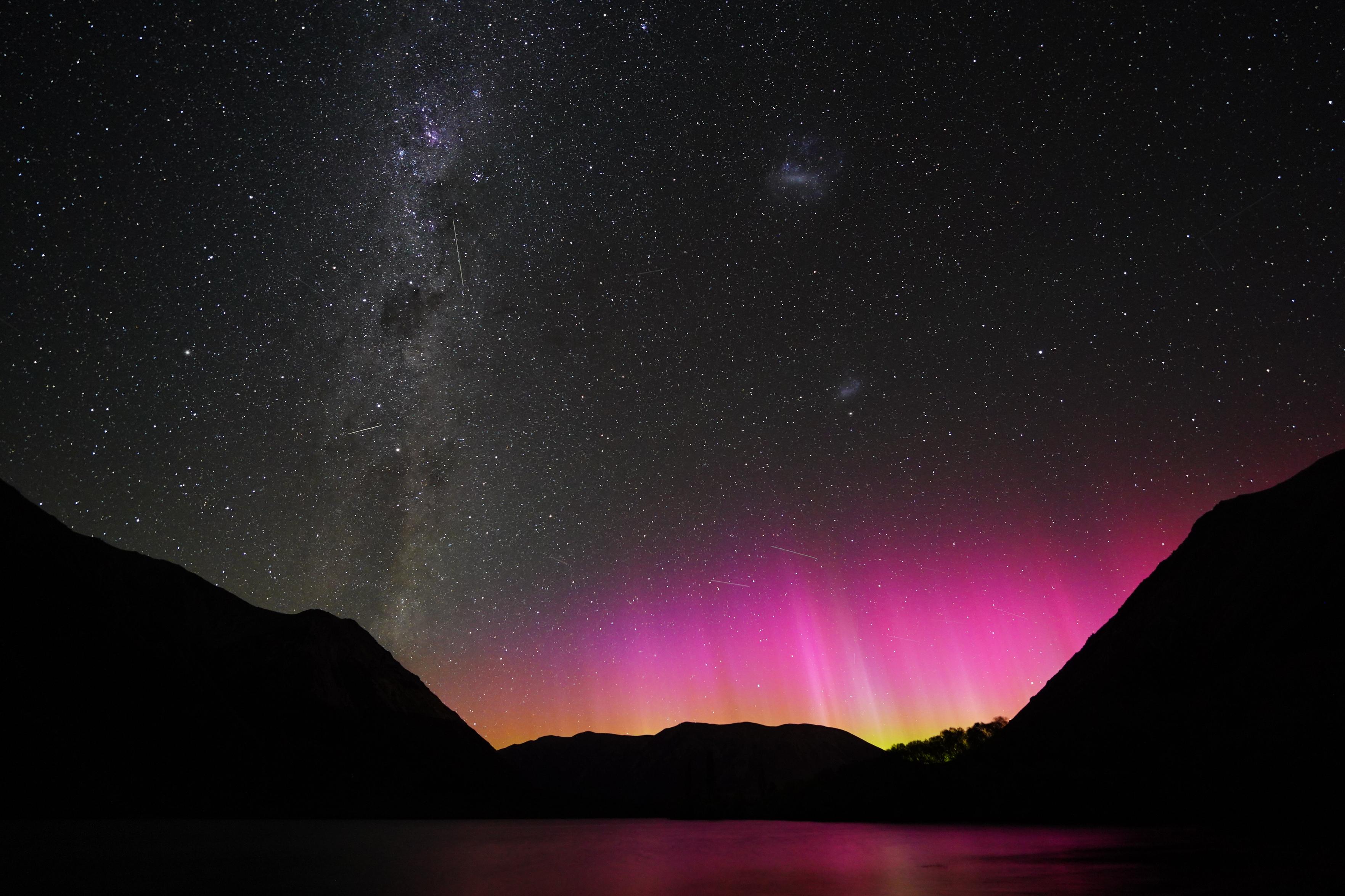 Same photo description as 2 posts earlier, but this one has several prominent satellite streaks crossing through the auroras and Milky Way
