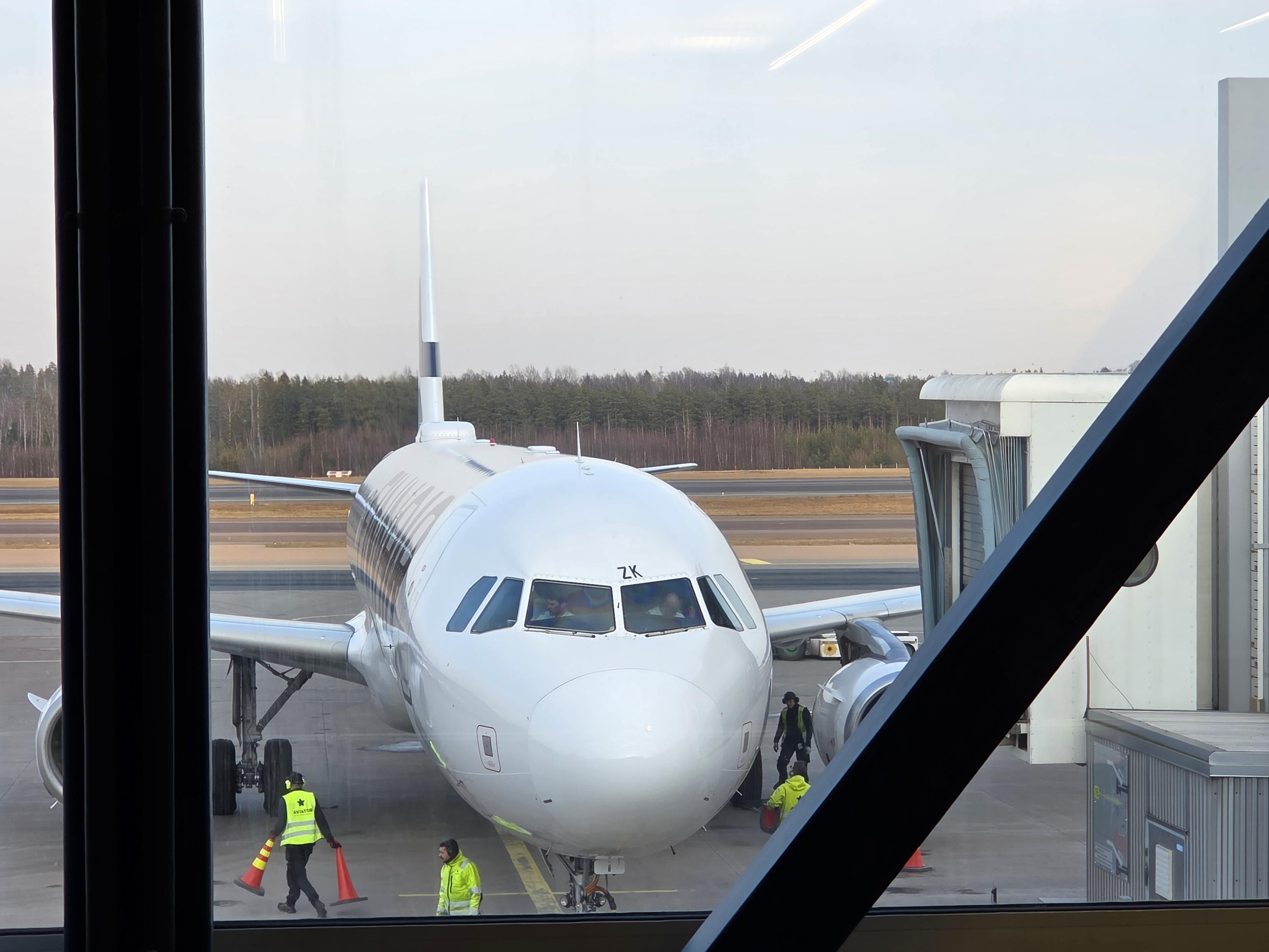 The front of a Finnair aeroplane seen from he terminal.