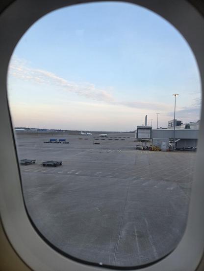 View out of the plane window of mostly blue sky. 