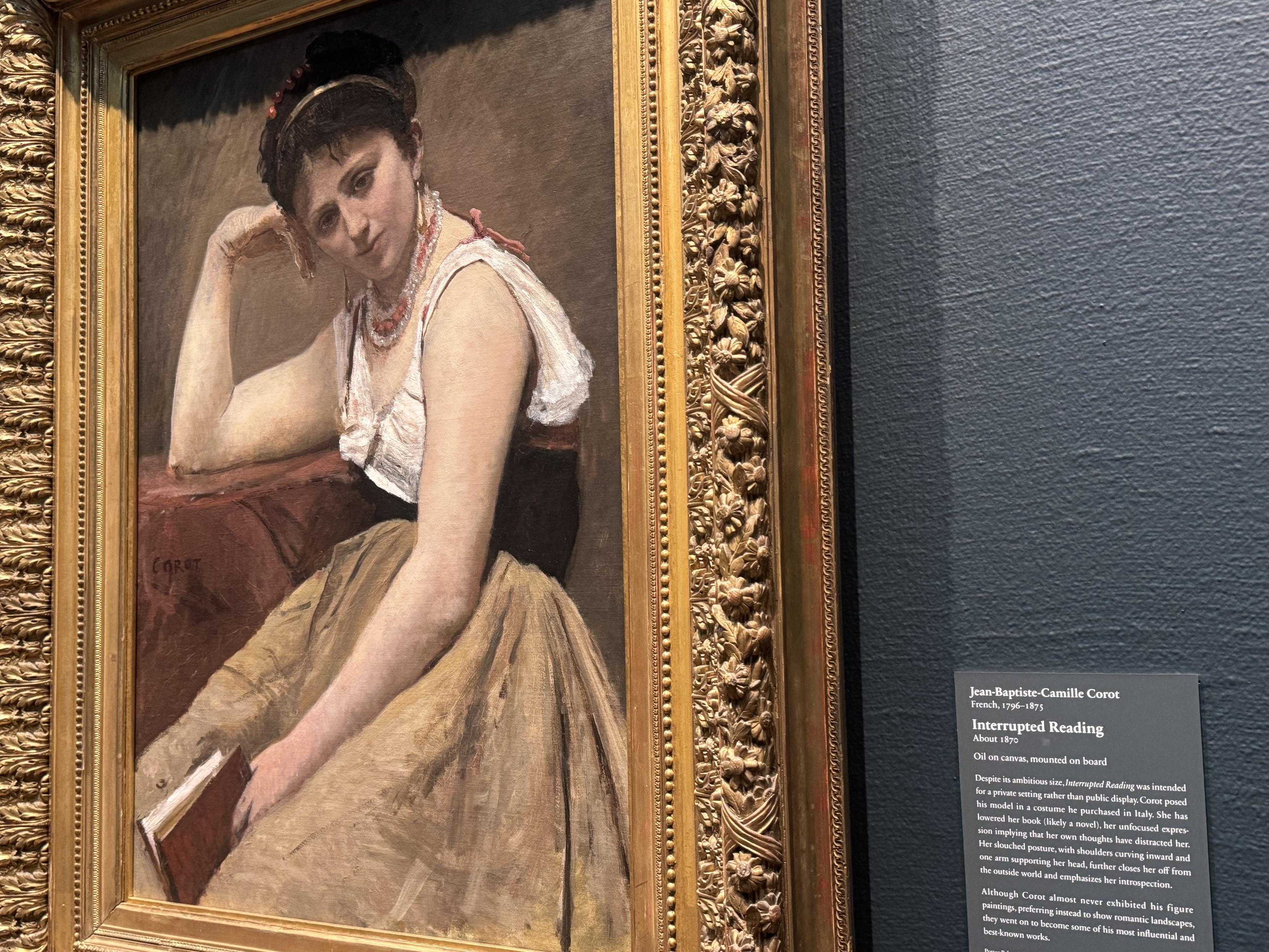 A painting of a woman, with a lowered book in her hand, looking g at the viewer with what I interpret as barely concealed annoyance.