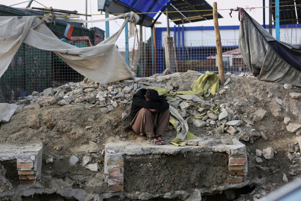 A man in despair at the ruins of a Kabul hospital destroyed by Pakistani strike.