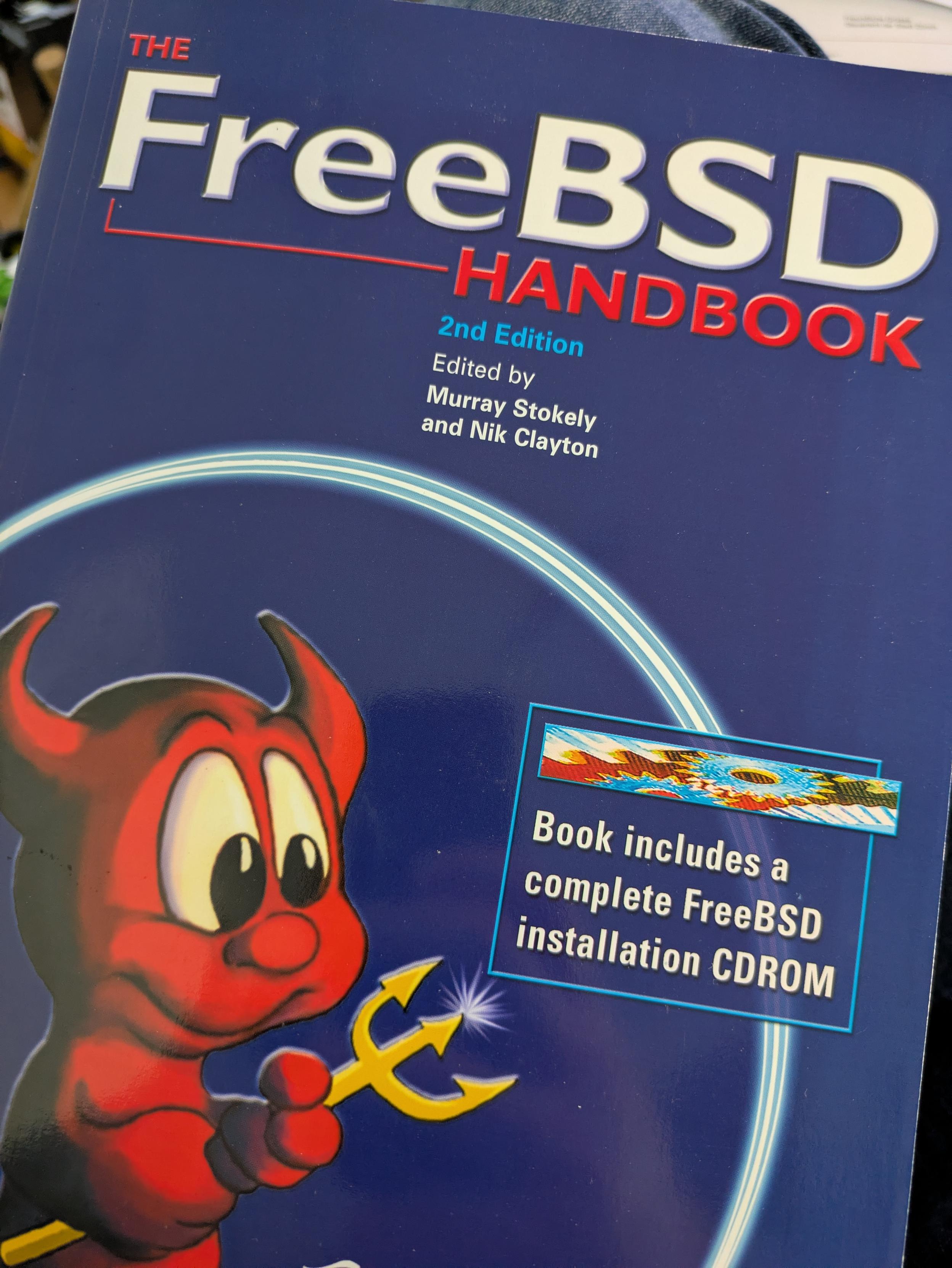 Photo of the front cover of the FreeBSD Handbook, second edition. Edited by Murray Stokely and Nik Clayton.