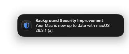 a macOS notification with an icon of a half-blue shield, reading
"Background Security Improvement"
"Your mac is now up to date with macOS 26.3.1 (a)"