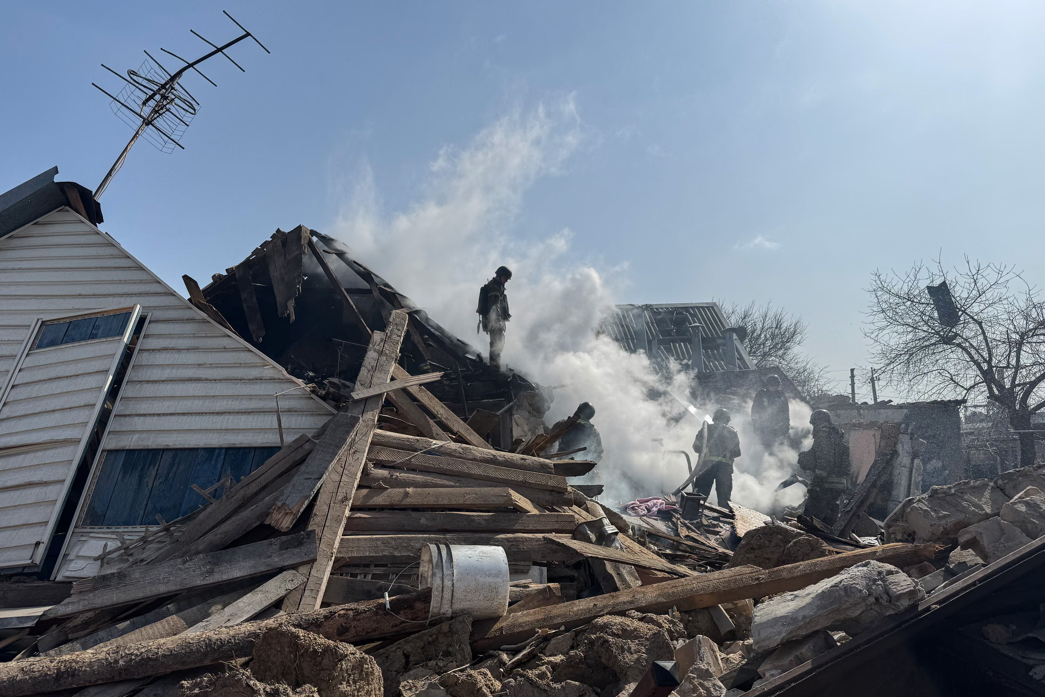 Firefighters work on a destroyed private house after a Russian drone attack.