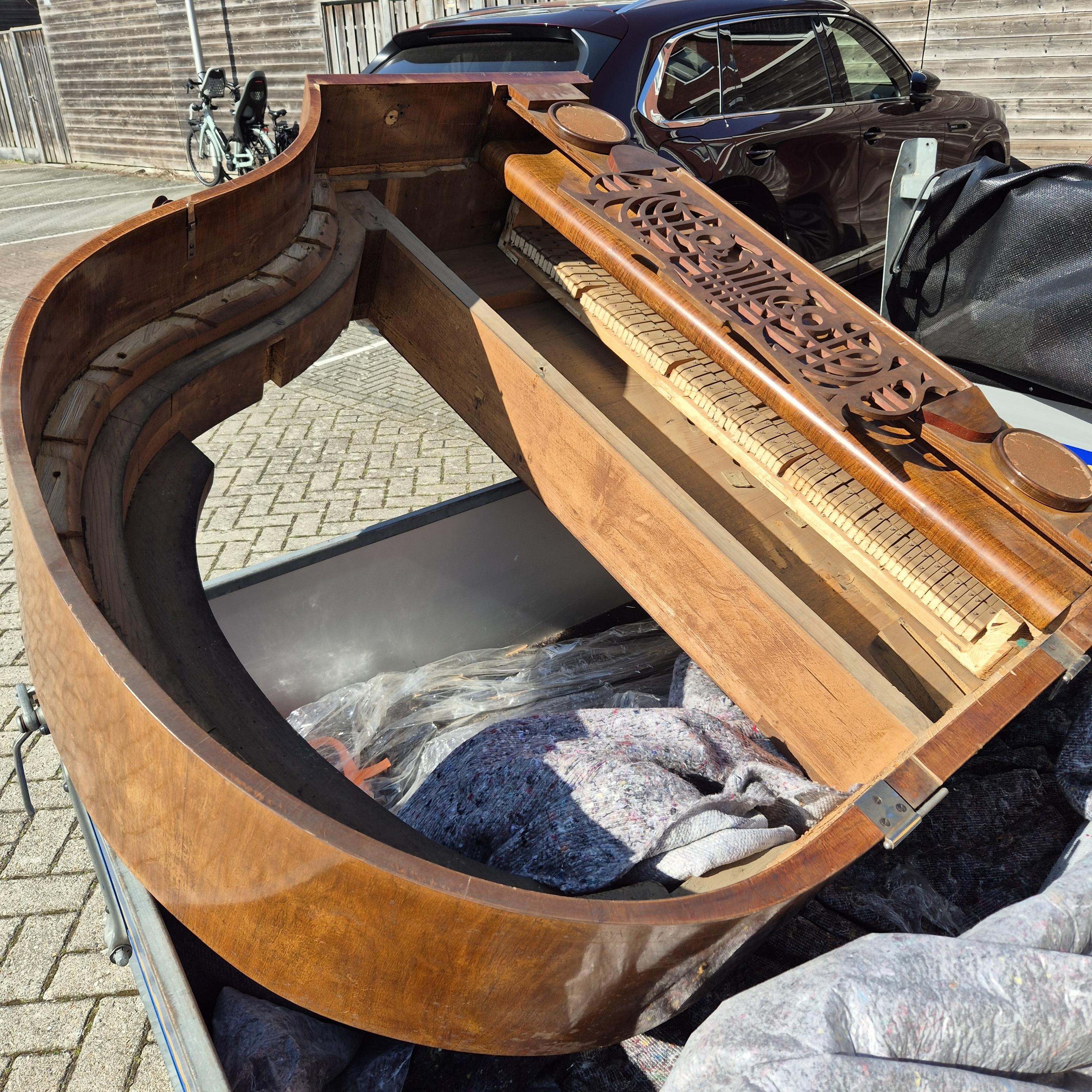 Empty shelf of a grand piano on a car trailer.
