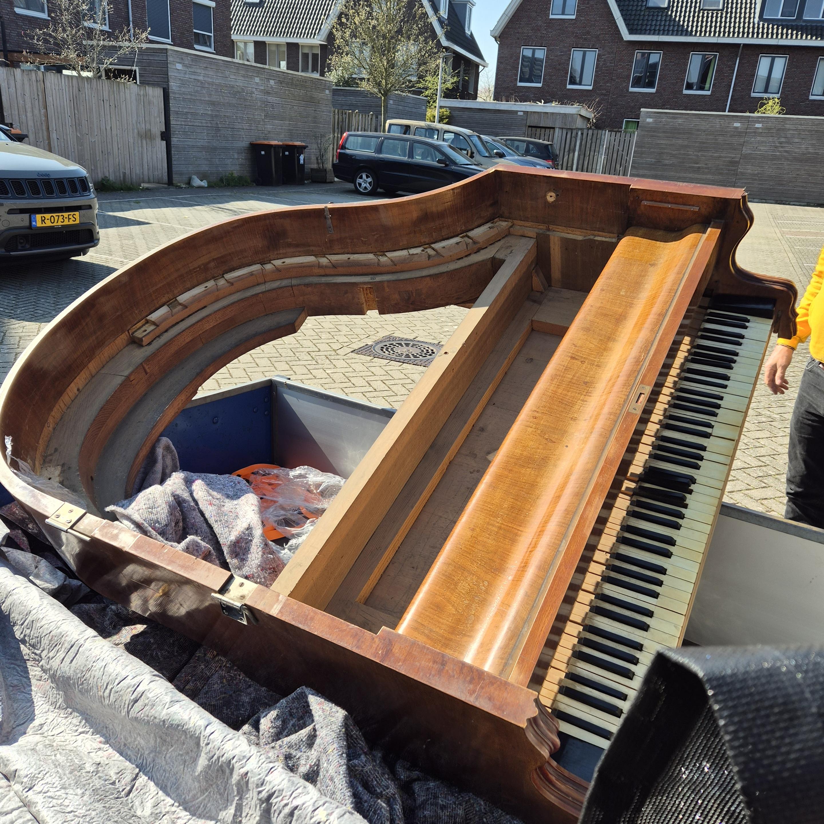 Empty shelf of a grand piano on a car trailer.