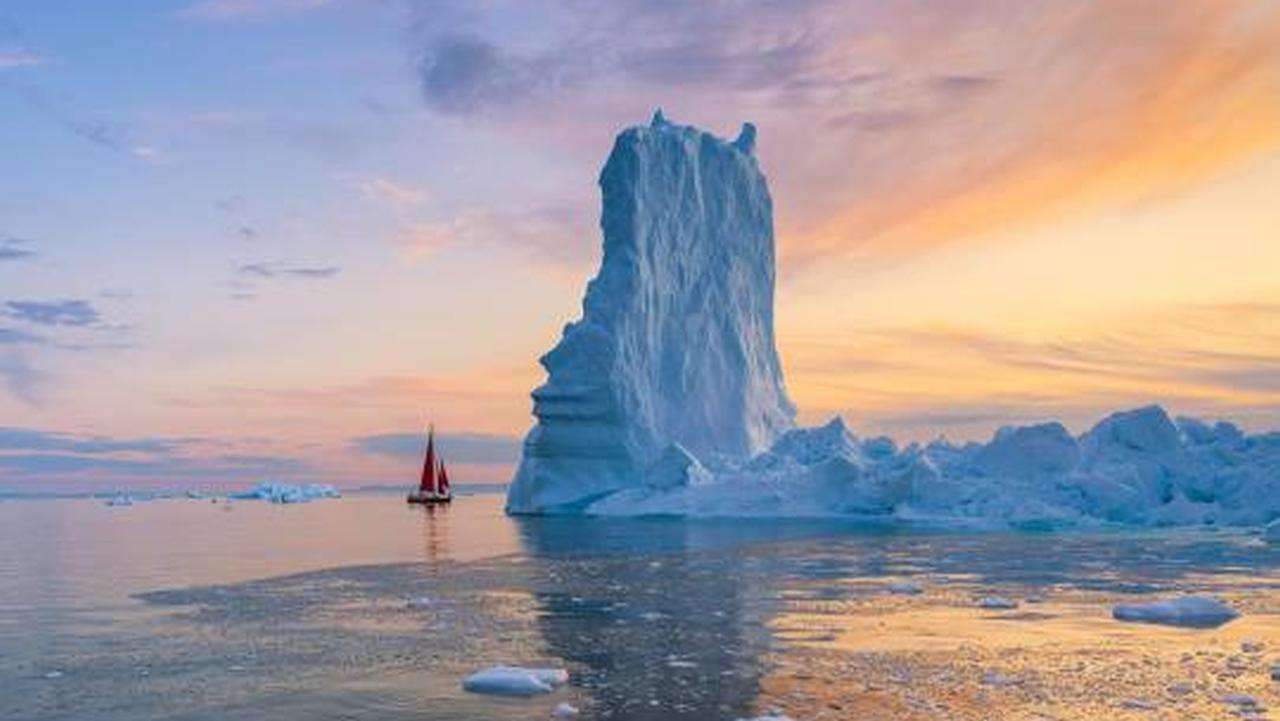 Ilulissat by Vincenzo Mazza.
( A red yacht near a towering blue glacier).