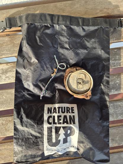 A cleanup bag with a rusty can and an old plastic thread on it