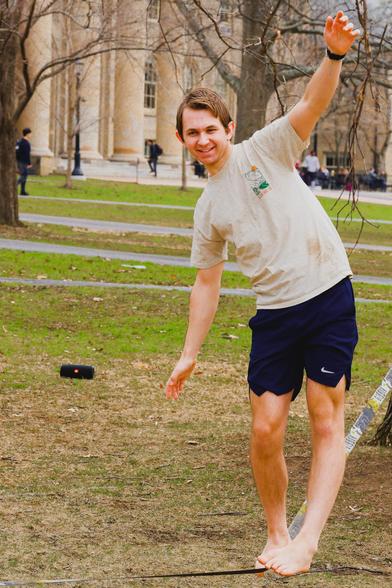 Man with light colored shirt smiles as he tries to shift his balance