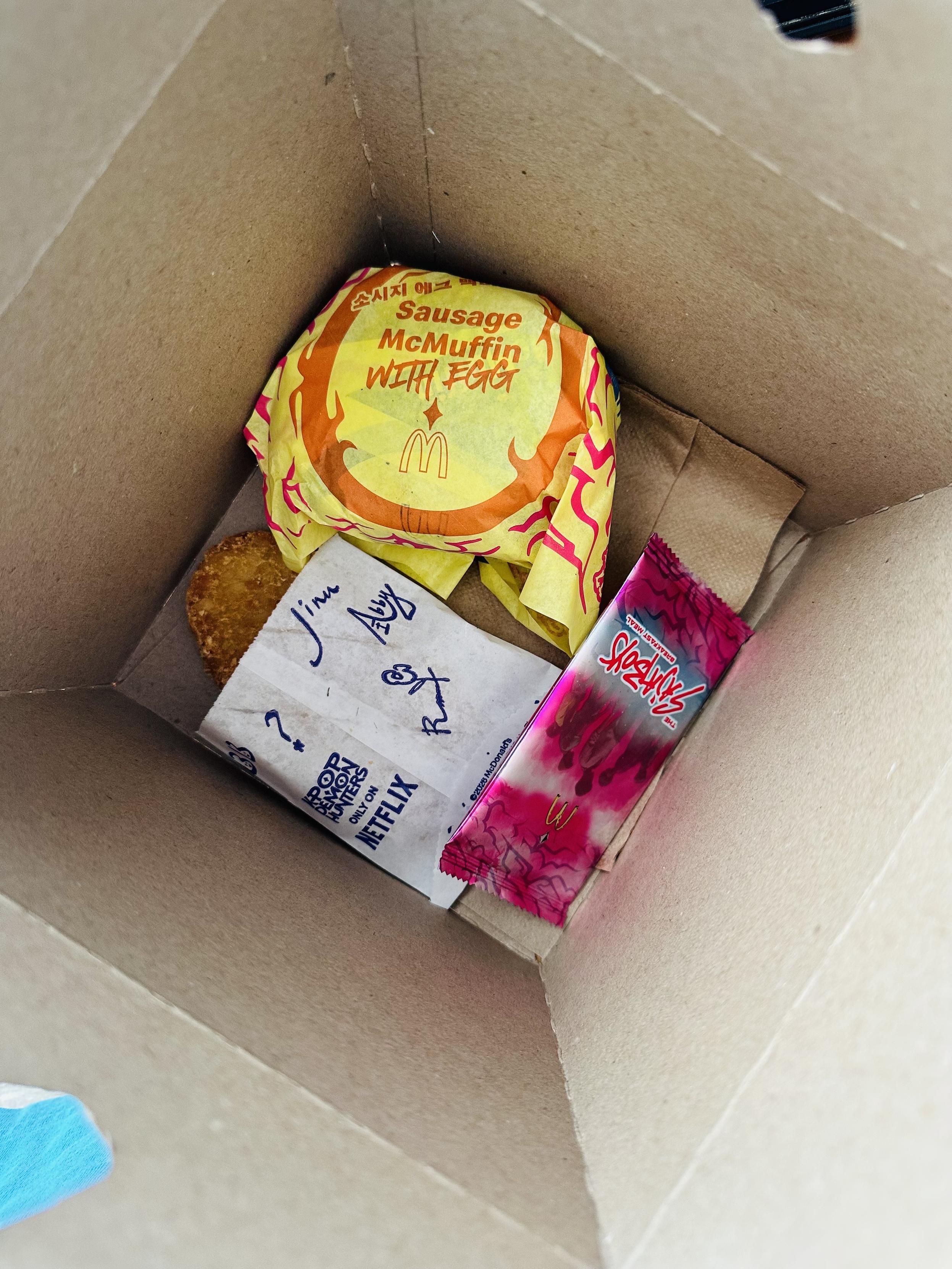 The inside of the happy meal box which is very large in proportion to the food, which sits at the bottom along with a collectors card