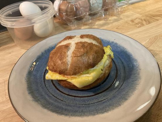 An egg and cheese sandwich on a pretzel bun.
