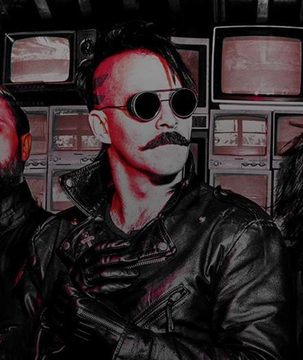 Lead singer of 3TEETH dressed in Leather, Mustache, shaved side head mohawk and welders glasses