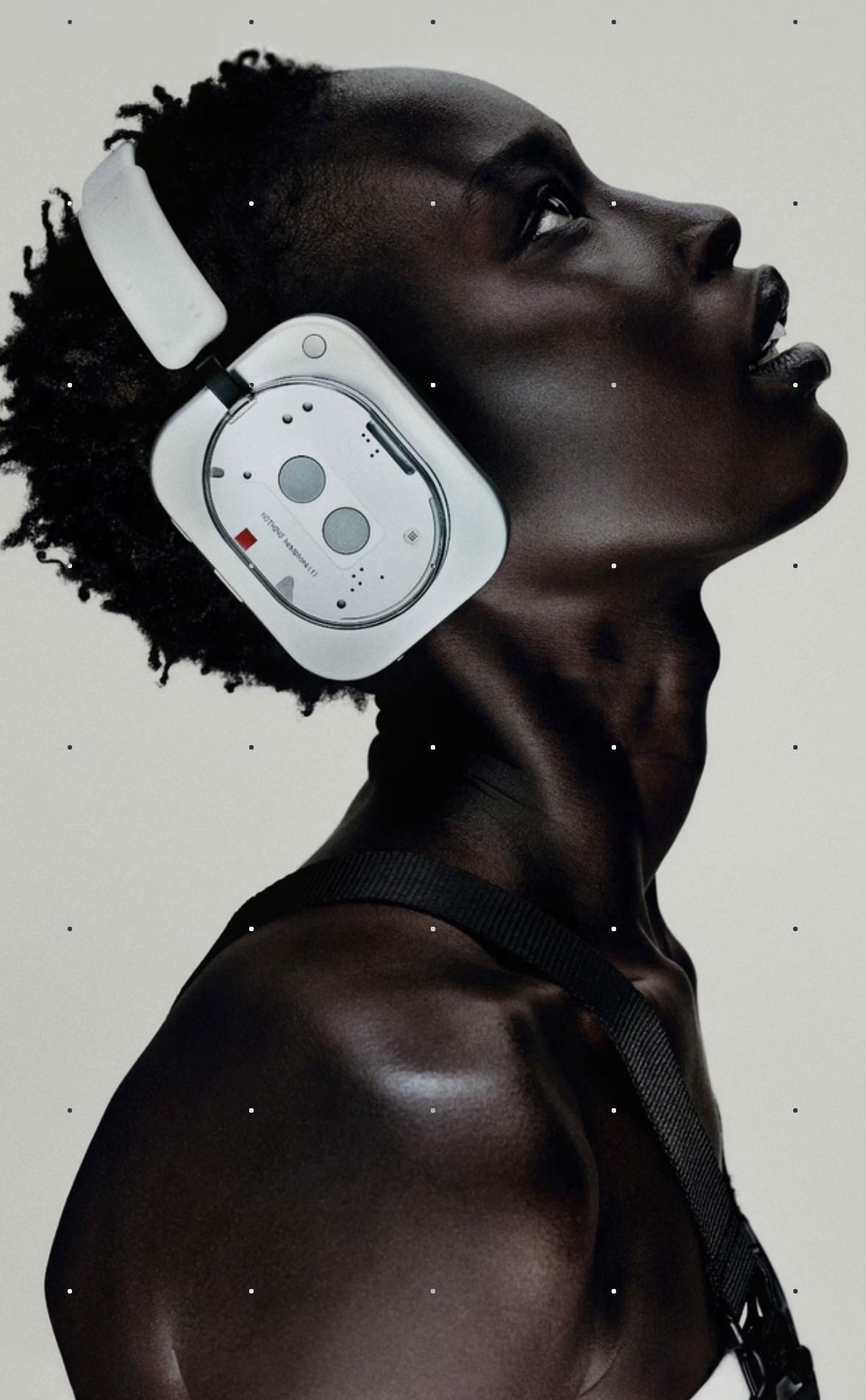 Woman, short hair with headphone on. The contrast of the white headphones and her darker skin is pleasant