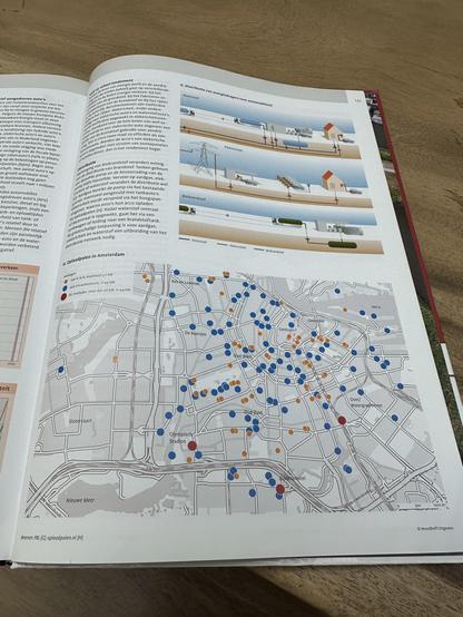 A paper book containing a map of Amsterdam showing charging points for electric cars