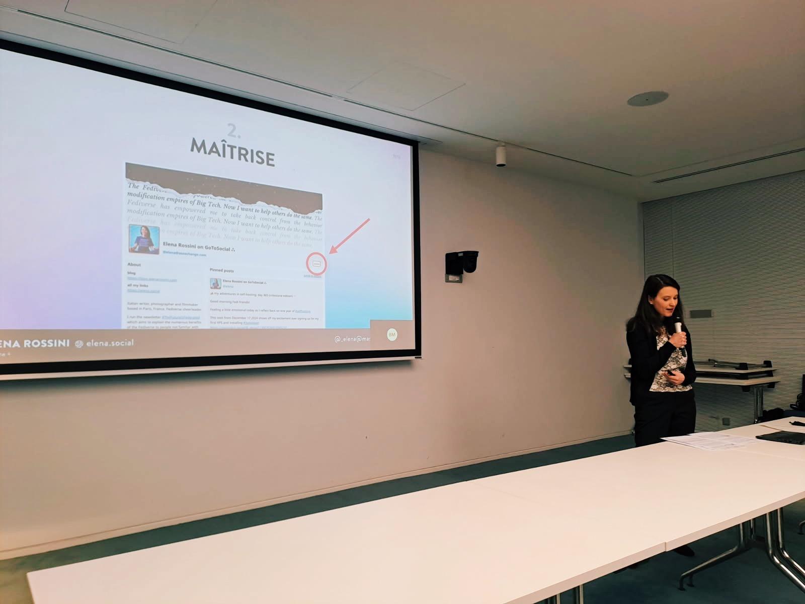 a photo of me standing up behind a table with a microphone in my hand and a slide behind me that says "control" with a screenshot of my self-hosted GoToSocial account with an arrow that points to "admin"