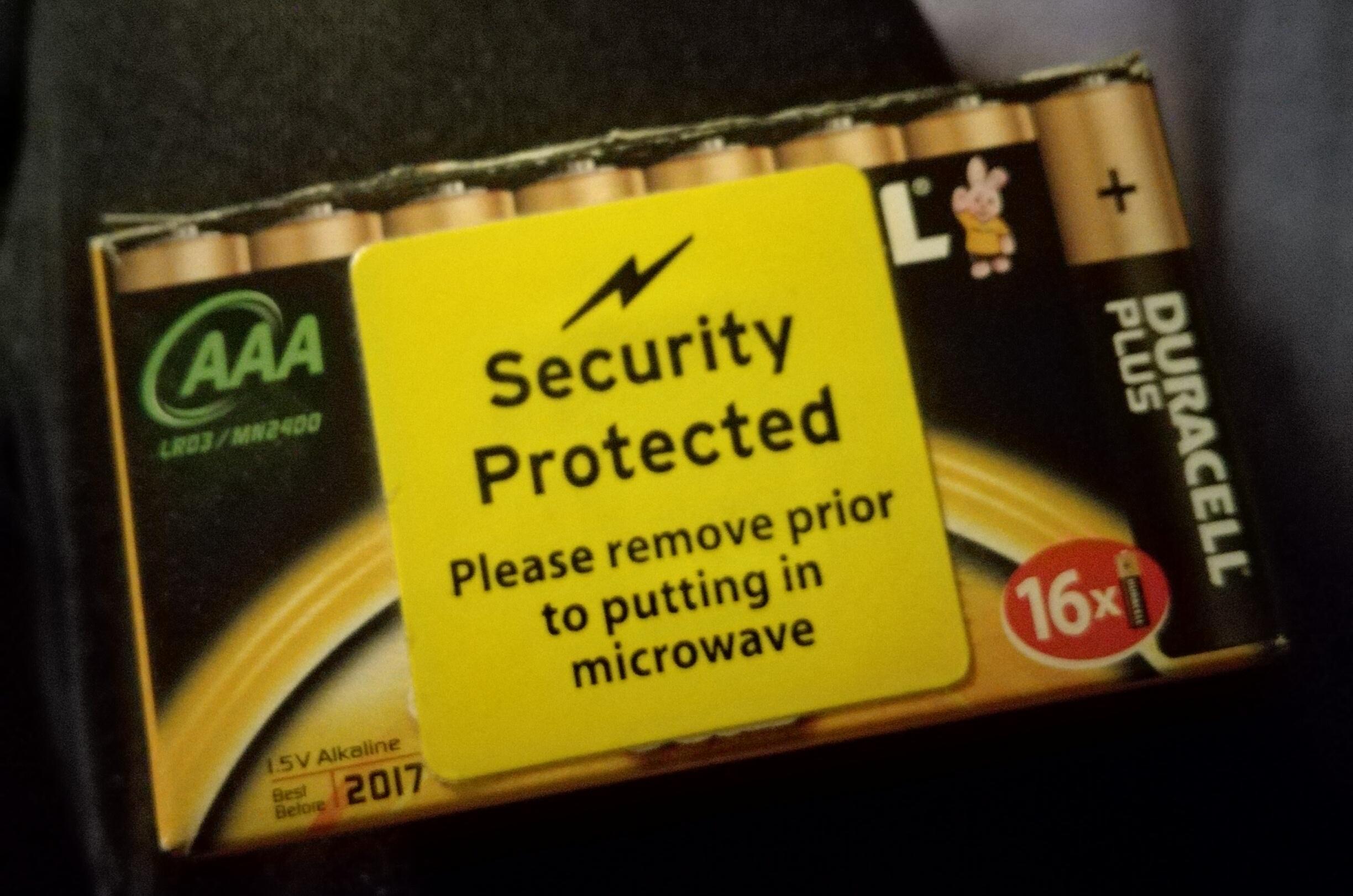 A pack of 16 AAA batteries. It has a prominent yellow sticker bearing the words:

Security Protected

Please remove prior to putting in microwave