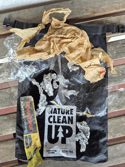 a "nature cleanup" bag with several kinds of litter on it that I found on my hike.
Aluminium foil, a plastic/paper bag and a wrapper for energy gel
